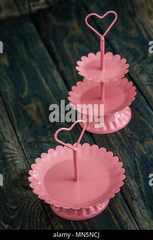 Pink tier serving trays on blue wooden background Stock Photo