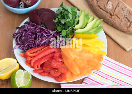 Rainbow salad with fresh baked, gluten free buckwheat bread. This healthy meal includes avocado, peppers, carrot tomato, beetroot, cabbage & peashoots. Stock Photo