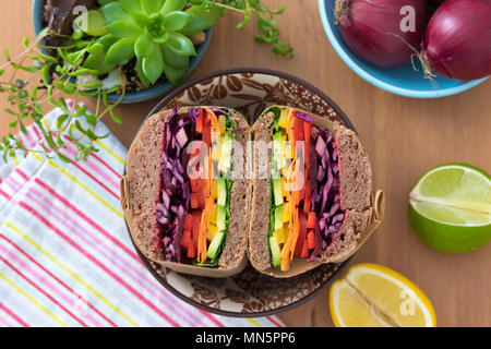 Rainbow salad sandwiches with homemade buckwheat bread, displayed on a wooden board. This fresh healthy lunch is low calorie, dairy free & gluten free. Stock Photo