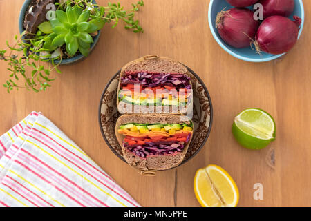 Rainbow salad sandwiches with homemade buckwheat bread, displayed on a wooden board. This fresh healthy lunch is low calorie, dairy free & gluten free. Stock Photo