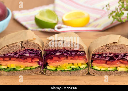Rainbow salad sandwiches with homemade buckwheat bread, displayed on a wooden board. This fresh healthy lunch is low calorie, dairy free & gluten free. Stock Photo