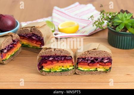 Rainbow salad sandwiches with homemade buckwheat bread, displayed on a wooden board. This fresh healthy lunch is low calorie, dairy free & gluten free. Stock Photo