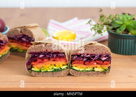 Rainbow salad sandwiches with homemade buckwheat bread, displayed on a wooden board. This fresh healthy lunch is low calorie, dairy free & gluten free. Stock Photo