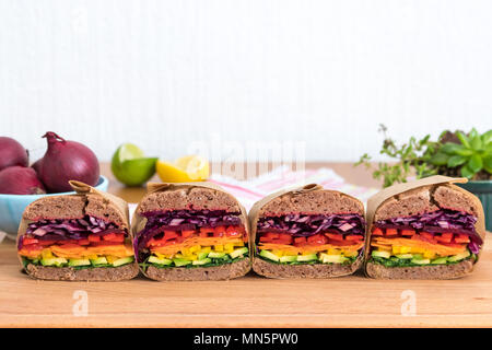 Rainbow salad sandwiches with homemade buckwheat bread, displayed on a wooden board. This fresh healthy lunch is low calorie, dairy free & gluten free. Stock Photo