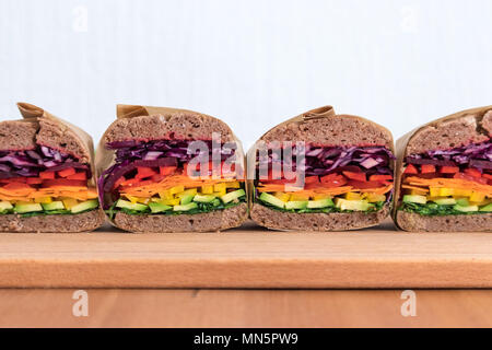 Rainbow salad sandwiches with homemade buckwheat bread, displayed on a wooden board. This fresh healthy lunch is low calorie, dairy free & gluten free. Stock Photo