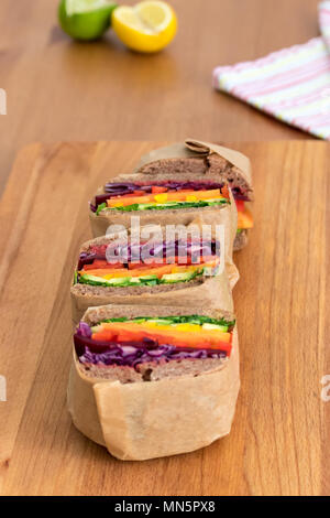 Rainbow salad sandwiches with homemade buckwheat bread, displayed on a wooden board. This fresh healthy lunch is low calorie, dairy free & gluten free. Stock Photo