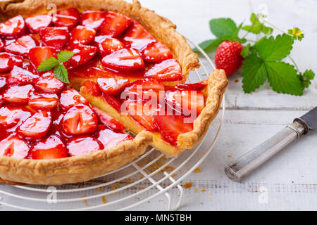 Homemade strawberry tart decorated with strawberry leaves close up Stock Photo