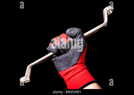 Box End Wrench tool in hand with protective gloves isolated on black background Stock Photo