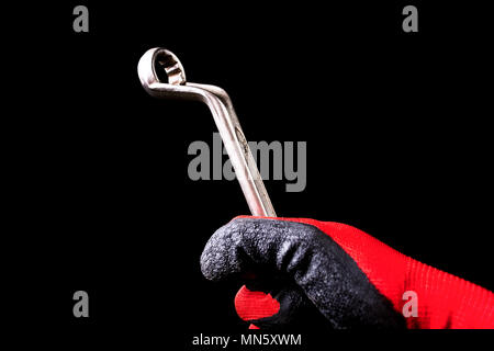 Hand with protective gloves holding Box End Wrench key tool. Close up Stock Photo