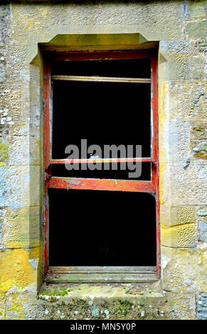 Red rotting wooden window frames of derelict building Stock Photo