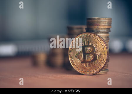 Trading with Bitcoin cryptocurrency, coin stack with laptop computer in defocussed background, conceptual image Stock Photo