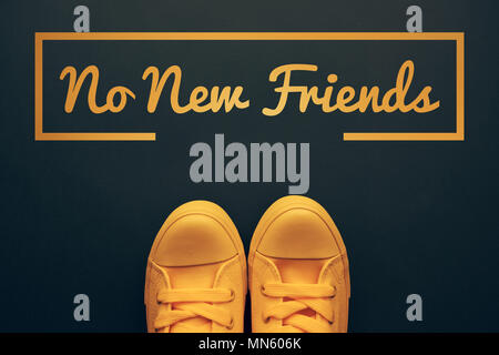 Words and phrases millennials use, conceptual image with young person in yellow sneakers standing directly above text - No new friends Stock Photo