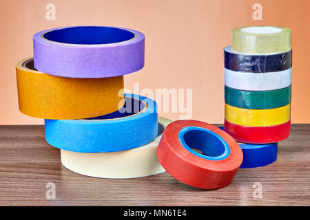 Two stacks of colorful rolls of duct tape on orange background. Stock Photo