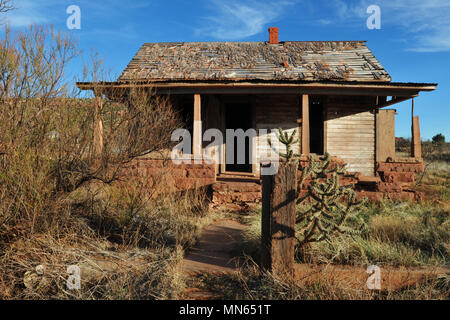An abandoned house on an overgrown lot in the Route 66 town of Cuervo, New Mexico. Stock Photo