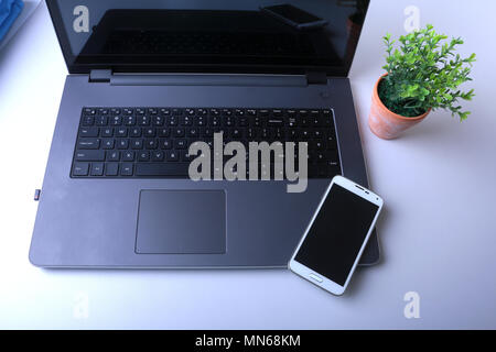 Office workplace with laptop, smart phone on table Stock Photo