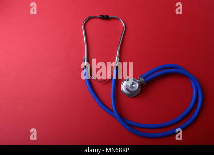 Medical blue stethoscope isolated on red background Stock Photo