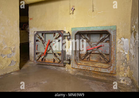 Rusty hatch emergency exit from the old underground shelter. Protective sealed doors with visible locking mechanism Stock Photo
