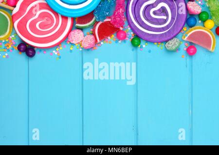 Top border of assorted colorful candies against a blue wood background Stock Photo