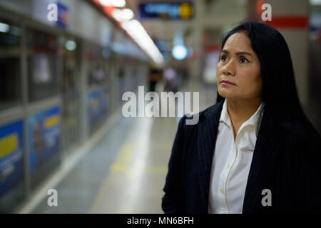 Mature beautiful Asian businesswoman inside the subway train sta Stock Photo