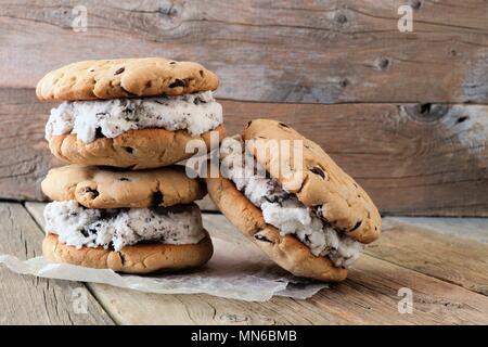 Homemade chocolate chip cookie ice cream sandwiches against a rustic wood background Stock Photo