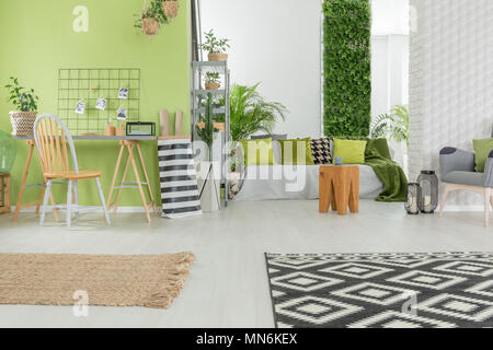Bright apartment in green and white with desk and sofa Stock Photo