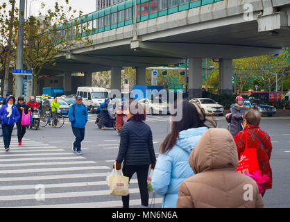 SHANGHAI, CHINA - DEC 23, 2016: People crossing the road in Downtown of Shanghai. Shanghai is one of the most populated cities in the world. Stock Photo
