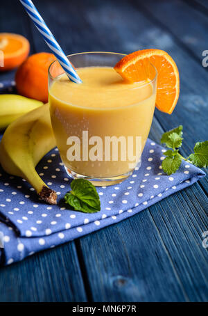 Fresh mandarin smoothie with banana and yoghurt in a glass jar