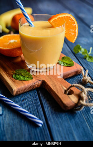 Fresh mandarin smoothie with banana and yoghurt in a glass jar