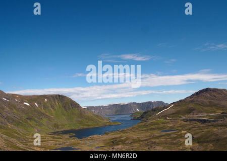 View on a bay near the North Cape in Norway on a calm summer day in July. The sky is mostly blue with some clouds far away. Stock Photo