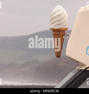 Ice cream van at Robin Hood's Bay Yorkshire with giant plastic ice cream cone and sea, cliffs and moorland in background Stock Photo