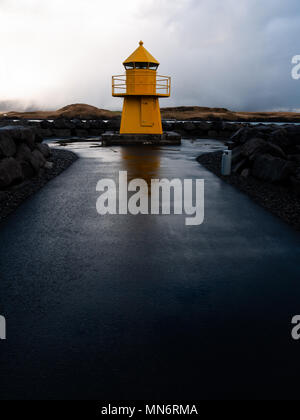 Reykjavík Norðurgarði (North Mole Head) yellow lighthouse, Reykjavik, Iceland with the island of Viðey and Viðey House in the background Stock Photo