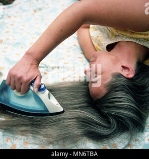 Woman Ironing her Hair Stock Photo Alamy