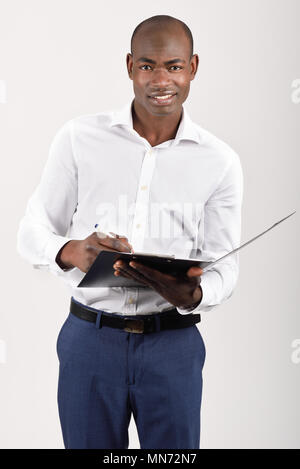 Portrait of black man wearing white shirt with a black folder in his hands in white background. Studio shot Stock Photo