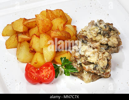 Beef medallions (beef in mushroom julienne with potato wedges). Stock Photo