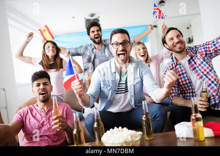 Soccer fans emotionally watching game in the living room. Stock Photo