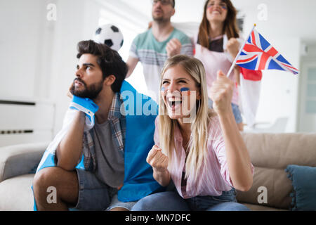 Group of football fans disappointed and happy watching a football game on the couch. Stock Photo