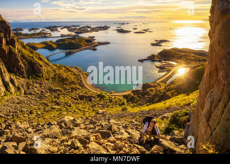 Hiker going to the top of mount Festvagtinden on Lofoten islands