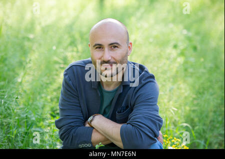 face of a bearded serious bald man in the park. Portrait of a middle-aged man.