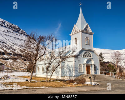 The famous Blue Church at Seydisfjordur, East Iceland, on a bright spring day with snowy mountains. Stock Photo