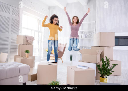 Happy young girls jumping in their new apartment Stock Photo