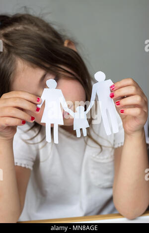 Little girl holds paper chain family; broken family or divorce concept Stock Photo