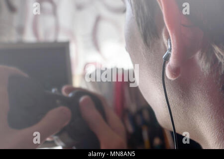 Portrait of young man with headphones holding a joystick controller in his hands Stock Photo
