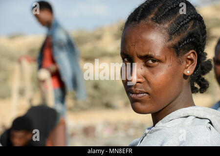 DJIBOUTI , Obock, from here ethiopian migrants try to cross bab el mandeb by boat to Yemen to go on to Saudi Arabia or Europe, ethiopian refugees from Tigray waiting outside the town for the smugglers, ethiopian orthodox christian with cross scar on the forehead / DSCHIBUTI, Obock, Meerenge Bab el Mandeb, mit Hilfe von Schleppern aethiopische Migranten versuchen hier nach Jemen ueberzusetzen, um weiter nach Saudi Arabien oder Europa zu gelangen, aethiopische Fluechtlinge aus Tigray warten ausserhalb der Stadt auf die Schmuggler, orthodoxe Christin mit auf der Stirn in die Haut eingeritztem Kre Stock Photo