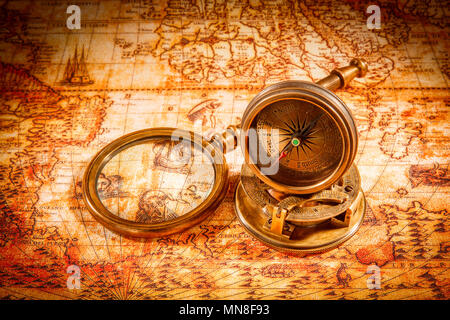 Vintage still life. Vintage compass lies on an ancient world map in 1565. Stock Photo
