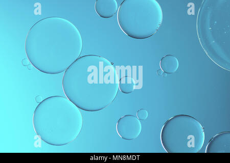 Water and oil on light blue background - Abstract macro Stock Photo