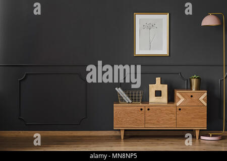 Simple retro living room interior with black walls, wooden floor, cupboard, lamp, ornaments and poster Stock Photo