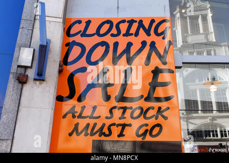 An unbranded sign in a British high street shop window announcing a closing down sale and that all stock must go. Stock Photo