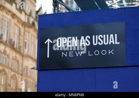 A banner announcing that a branch of the fashion chain New Look is open as usual. Stock Photo