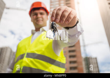 Portrait of smiling male architect posing over new building and holding keys in hands Stock Photo