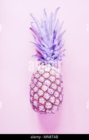 Top view of a single Pineapple isolated against an orange background, pink tonality added in out procession to create a moody and abstract concept. Stock Photo